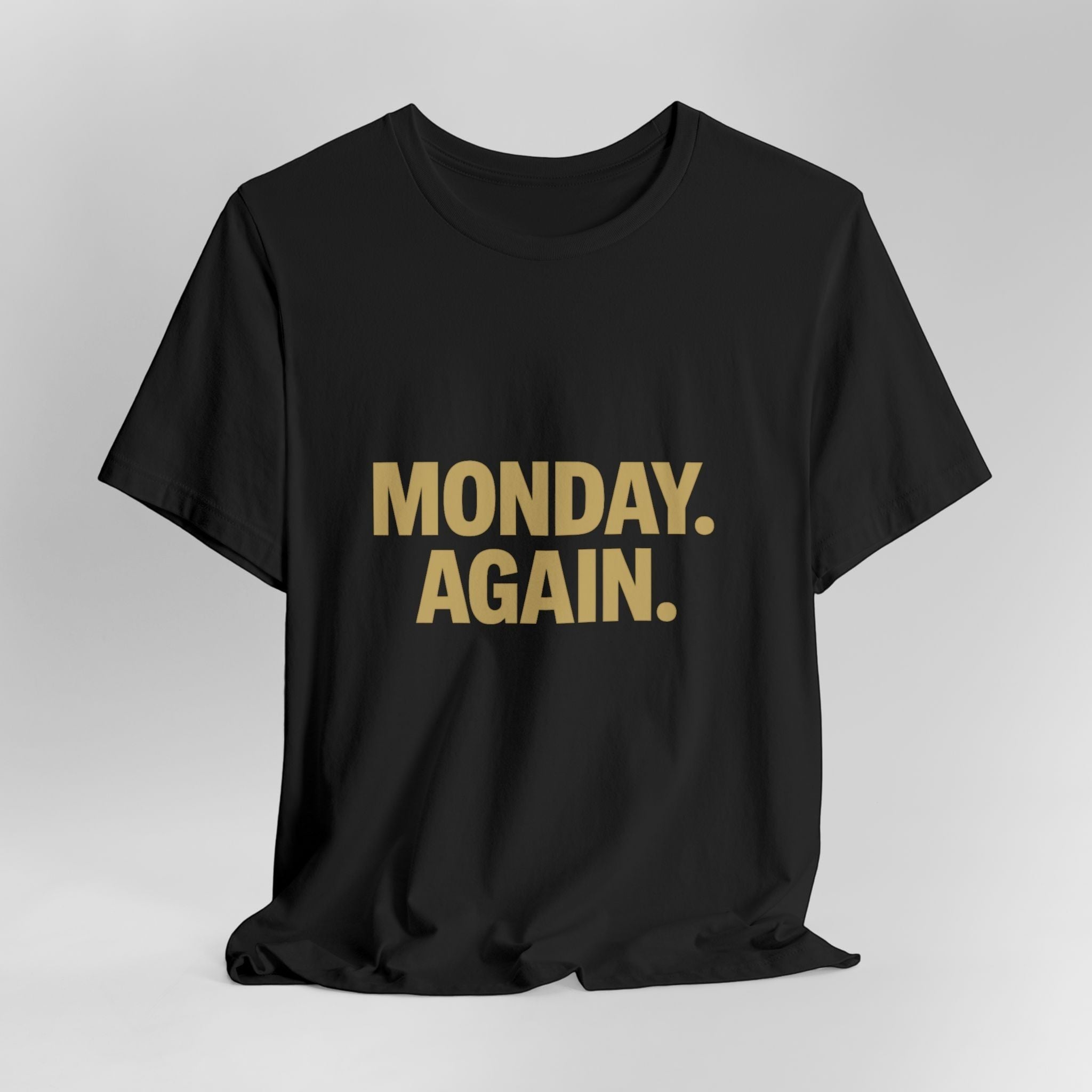 The "Monday. Again." T-Shirt by Old Man Snark from Printify features bold gold MONDAY. AGAIN. text on black Airlume cotton, displayed on a plain light background—a motivational statement for any day.