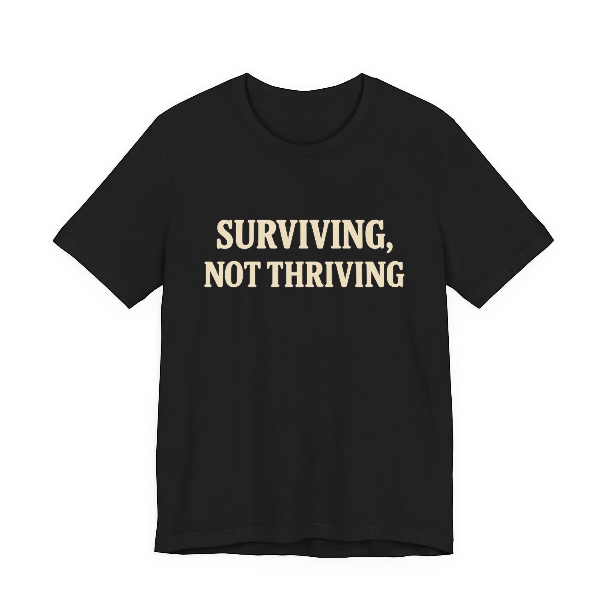 The "Surviving. Not Thriving." T-shirt by Printify is a black tee from Old Man Snark, crafted with soft Airlume cotton and bold beige lettering—a modern take on life's challenges.