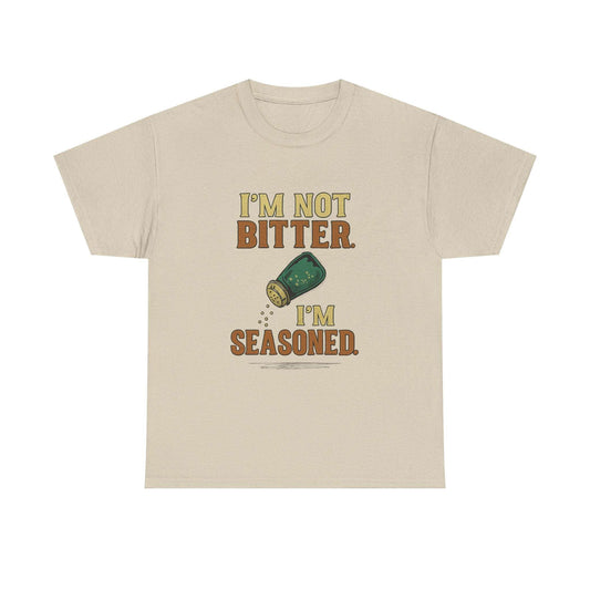 Unisex heavy cotton beige t-shirt with funny cooking slogan "I'm not bitter. I'm seasoned." and green spice shaker graphic