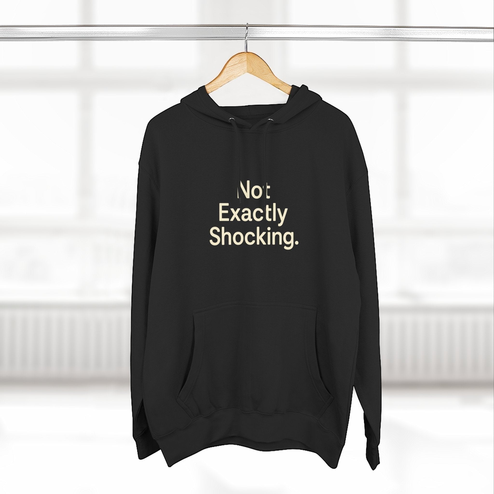 Old Man Snark black midweight fleece hoodie featuring the minimalist text Not Exactly Shocking on the chest.