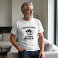 Old Man Snark off-white cotton t-shirt with funny marriage quote and graphic on a mature man in a living room.
