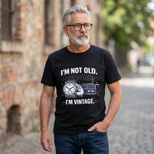 Old Man Snark black cotton t-shirt with I'm Not Old I'm Vintage slogan worn by a mature man with grey hair and glasses.