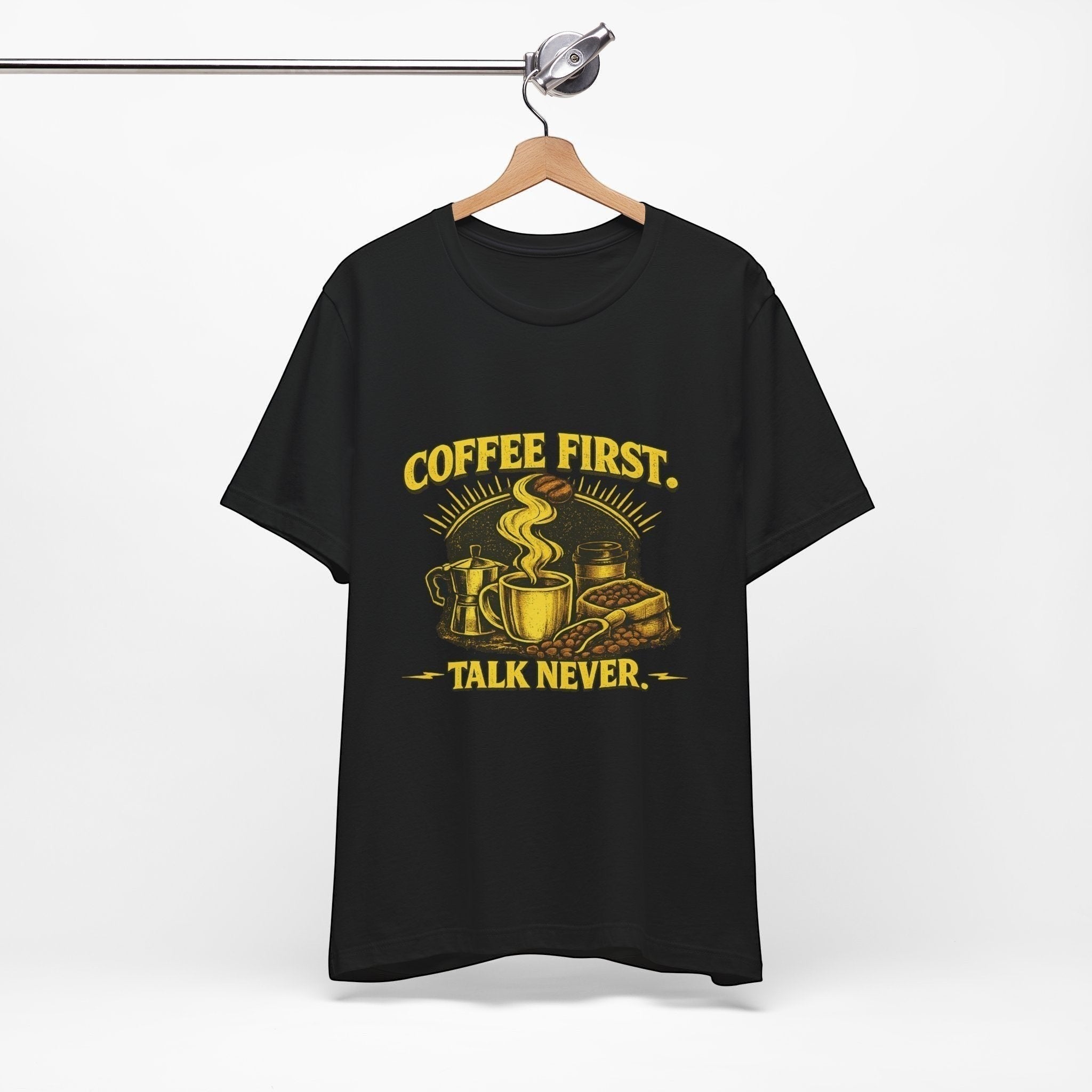 Old Man Snark black cotton t-shirt with yellow "COFFEE FIRST. TALK NEVER." graphic featuring a steaming mug, moka pot, and coffee beans.