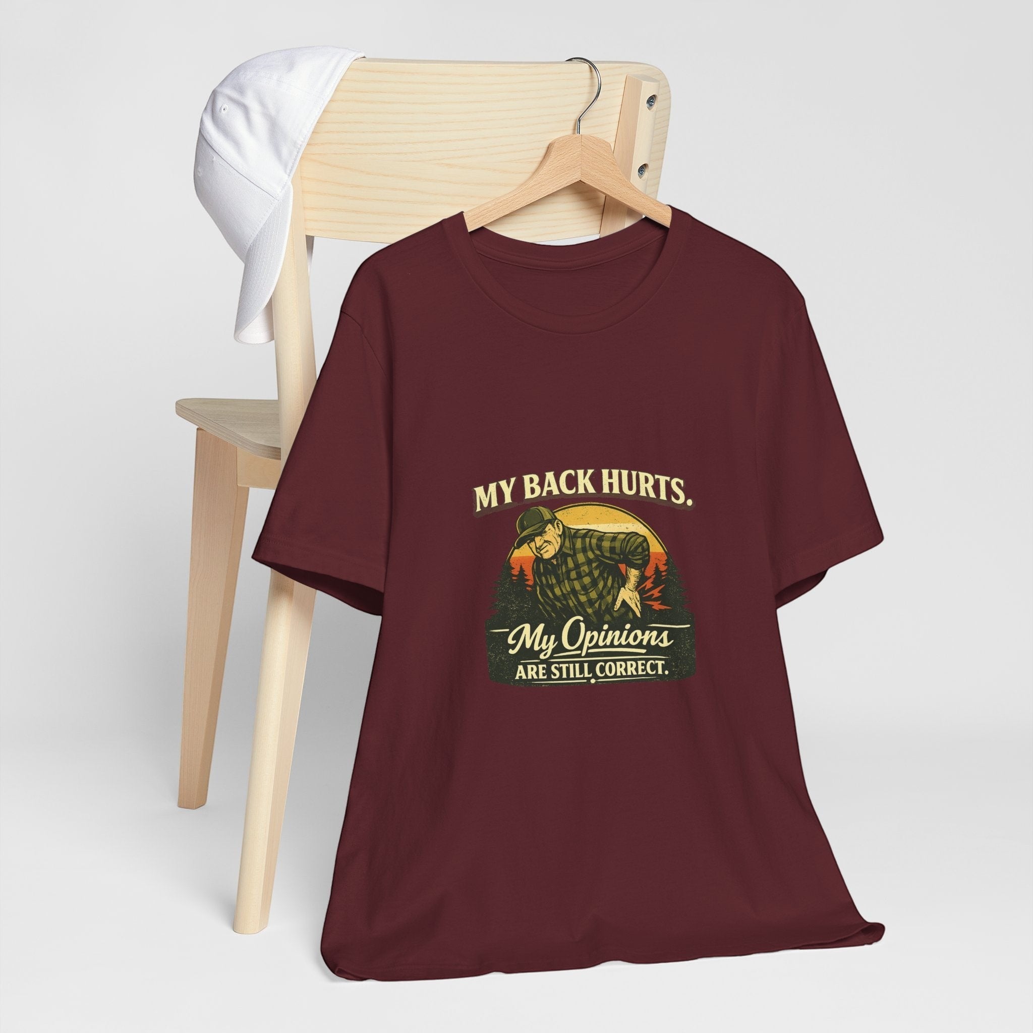 Old Man Snark burgundy 100% cotton t-shirt with a vintage graphic of a man holding his back, text reads "My Back Hurts. My Opinions ARE STILL CORRECT."