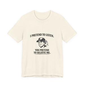 Old Man Snark off-white 100% cotton t-shirt with a graphic that reads "I PRETEND TO LISTEN." above a man cupping his ear, and "YOU PRETEND TO BELIEVE ME." below.