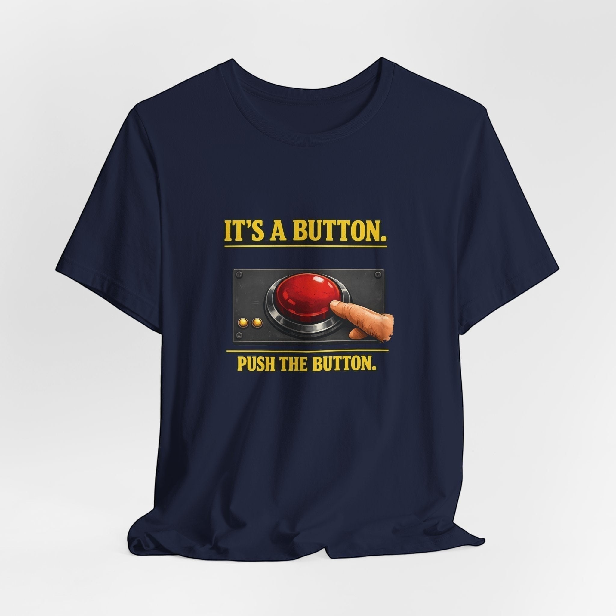 The "It's A Button. Push The Button." T-Shirt by Old Man Snark from Printify features soft Airlume cotton, a finger pressing a large red button, and playful tech support text—perfect for any IT enthusiast.