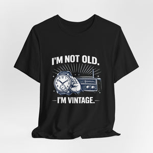 Old Man Snark black cotton t-shirt with "I'm Not Old, I'm Vintage" graphic featuring a hand holding a watch and a vintage radio.