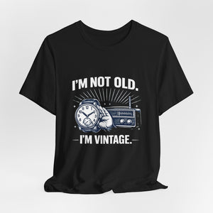Old Man Snark black cotton t-shirt with "I'm Not Old, I'm Vintage" graphic featuring a hand holding a watch and a vintage radio.